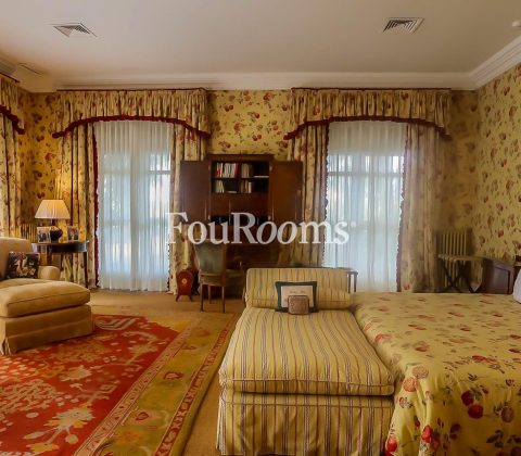 Dormitorio con cama grande y papel pintado en las paredes