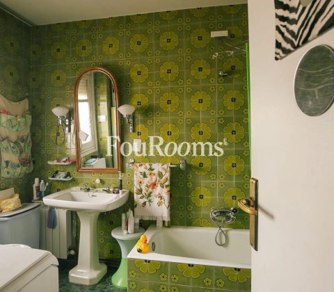 baño con azulejos de flores verdes