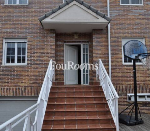 casa con fachada de ladrillo y puerta principal con escaleras