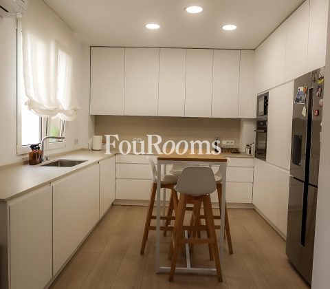 cocina con muebles blancos y encimera de madera