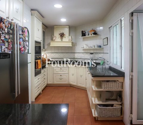 cocina con muebles blancos y nevera con imanes