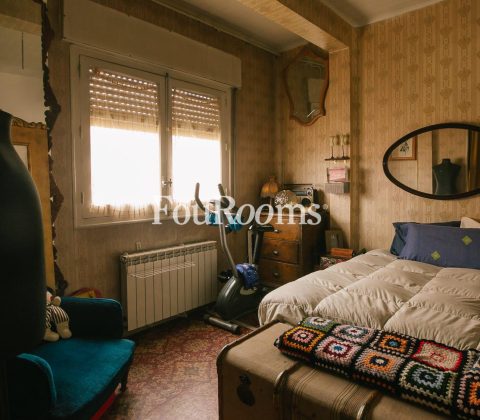 dormitorio con cama, baúl y ventana