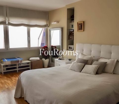 dormitorio con cama grande, ventana y paredes en tonos beiges