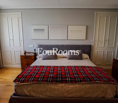dormitorio con cama grande y colcha escocesa