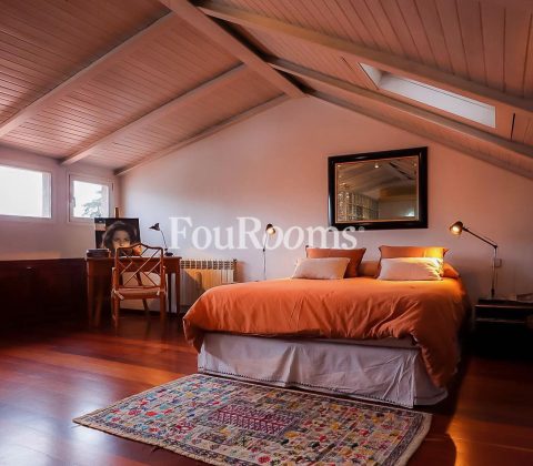 dormitorio con cama grande y techo abuardillado