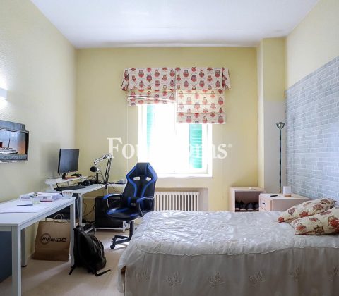 dormitorio con cama, mesa y silla