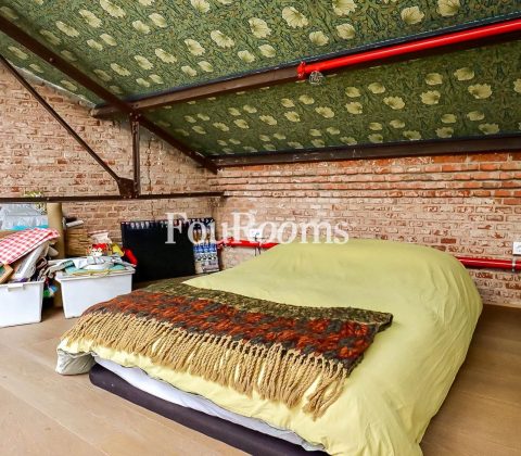 dormitorio con cama y techo inclinado