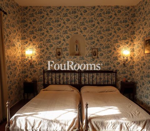 dormitorio con dos camas y papel de flores