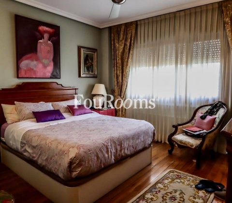 dormitorio principal con cama grande y cuadros en las paredes