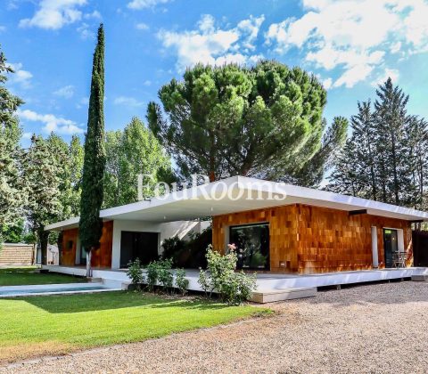exterior de chalet de una planta con jardín y piscina