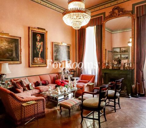 interior salón de palacete con sofá y cuadros en las paredes