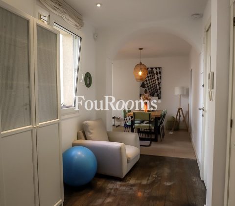 pasillo con sofá blanco y balón grande azul