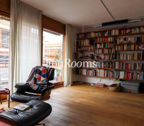 sala con butaca, libreria y ventanal
