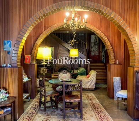 sala de estar con mesa redonda y sillas y techo abovedado con arcos de ladrillo