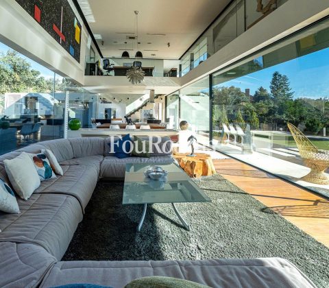 salón con dos alturas, sofá y ventanales