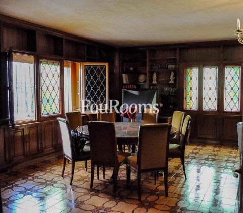 salón con paredes de madera y mesa redonda con sillas