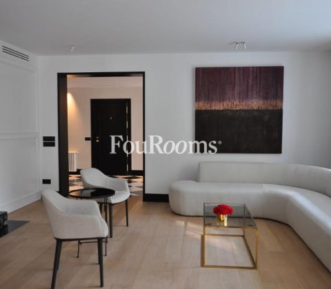 salón con sofá blanco y dos butacas