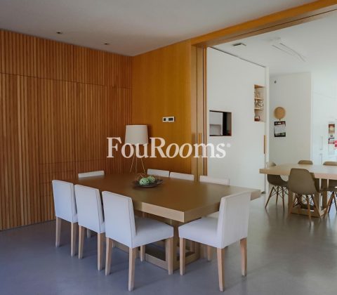 vista de comedor con mesa y sillas y cocina con muebles modernos